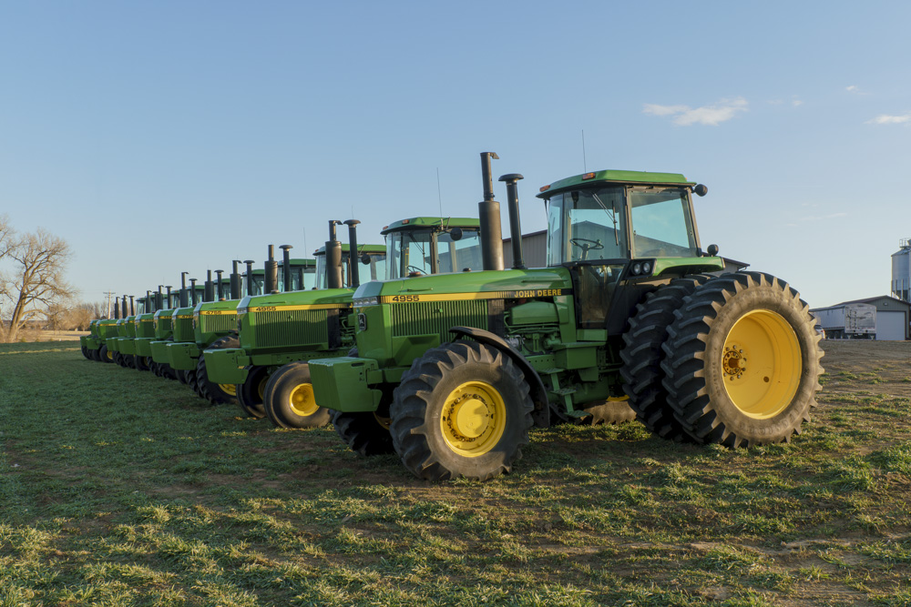 55-Series John Deere SoundGard tractors lined up at sunset