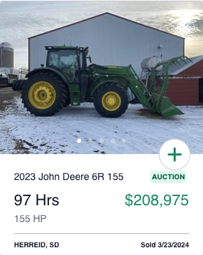 2023 John Deere 6R 155 in front of a machine shed